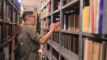 Operario de limpieza limpiando biblioteca universitaria