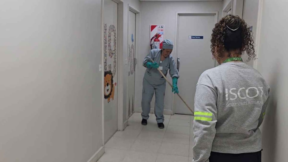 Supervisora de ISCOT acompañando a una colaboradora durante la limpieza de un pasillo de la clínica