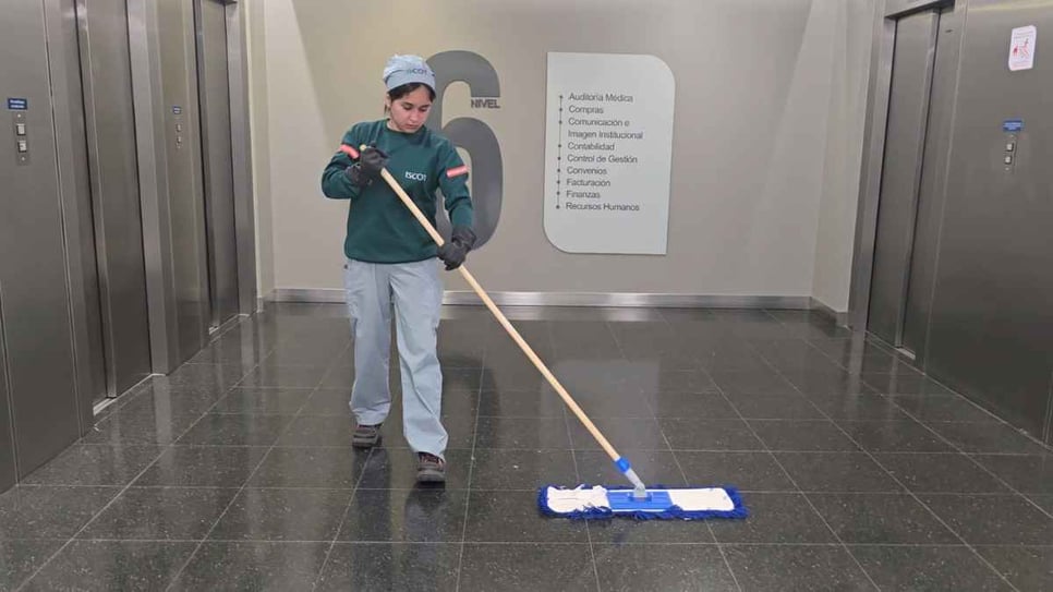 Colaboradora de ISCOT limpiando el hall del nivel 6 de la Clínica Universitaria Reina Fabiola